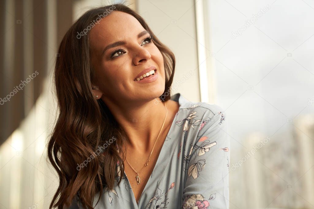 Beautiful young happy woman smiling looks away on the city background