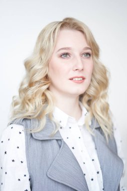 Gri arka planda gülümseyen güzel bir kadın, bir uzmanın iş portresi.