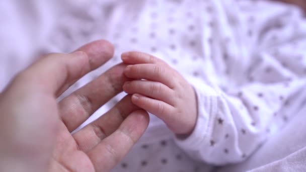 Медленное видео, где мать берет своего новорожденного ребенка за руку — стоковое видео