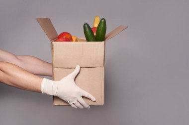 Bir kurye eldiven içinde bir kutu erzak, fast-and-food teslimatı.