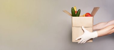Bir kurye eldiven içinde bir kutu erzak, fast-and-food teslimatı.