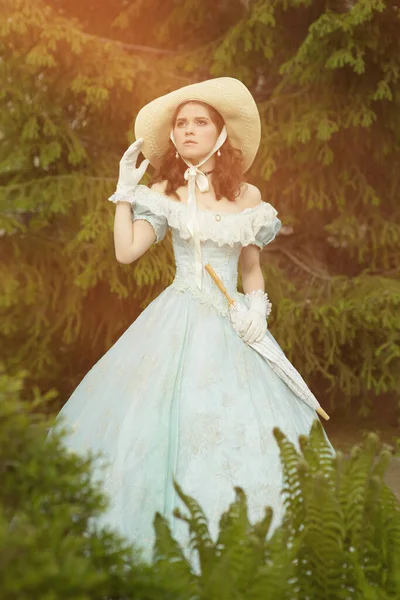 Een mooie jonge vrouw in een historische blauwe jurk 1860 jaar. Boekomslag ontwerp. — Stockfoto