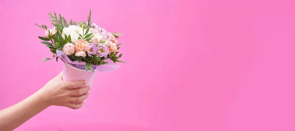 Ramillete de flores mixtas en mano sobre banner de fondo rosa con espacio para copiar — Foto de Stock