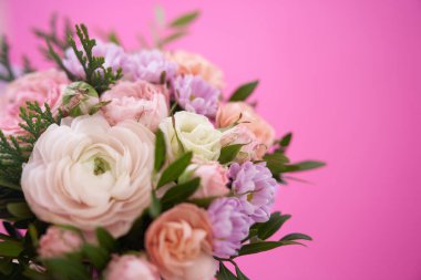 Pembe arka planda bir buket karışık çiçek.