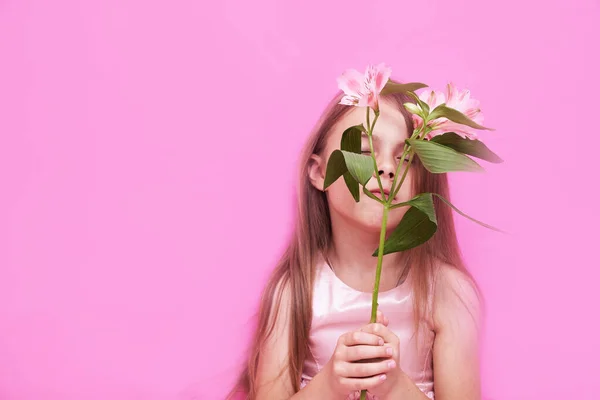 Alstroemeria en la mano de las niñas sobre un fondo rosa — Foto de Stock