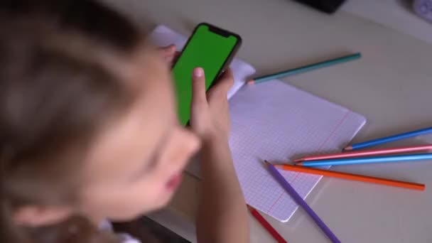Ein kleines Mädchen spielt auf ihrem Handy, hört Musik und tanzt, statt Unterricht zu nehmen — Stockvideo