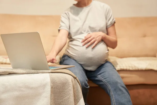 Schwangere sitzt zu Hause mit Computer, Online-Shopping oder Home Office — Stockfoto