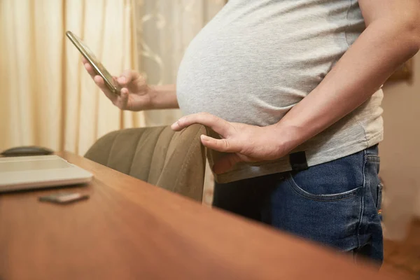 Schwangere zu Hause mit Telefonständern am Tisch, Online-Shopping — Stockfoto