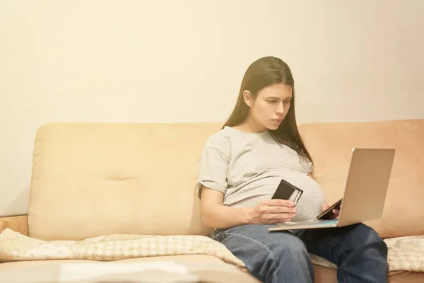 Schwangere mit Handy zu Hause sitzt am Computer, Online-Shopping — Stockfoto