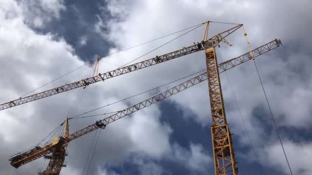 Dois guindastes de elevação amarelos no céu azul com belas nuvens, trabalhos de construção — Vídeo de Stock