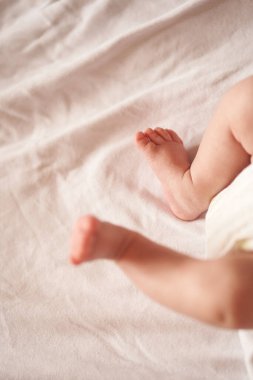 Bebek bacakları beyaz çarşafta, yeni doğmuş bebek 1 ay, ilgi ve sevgi