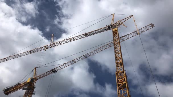 Dois guindastes de elevação amarelos no céu azul com belas nuvens, trabalhos de construção — Vídeo de Stock