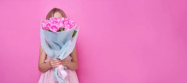 Una chica en vestido rosa con ramo de rosas, se escondió detrás de las flores. — Foto de Stock