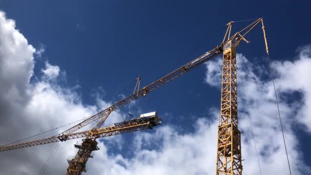 Dos grúas elevadoras amarillas en el cielo azul con hermosas nubes, trabajos de construcción — Vídeo de stock