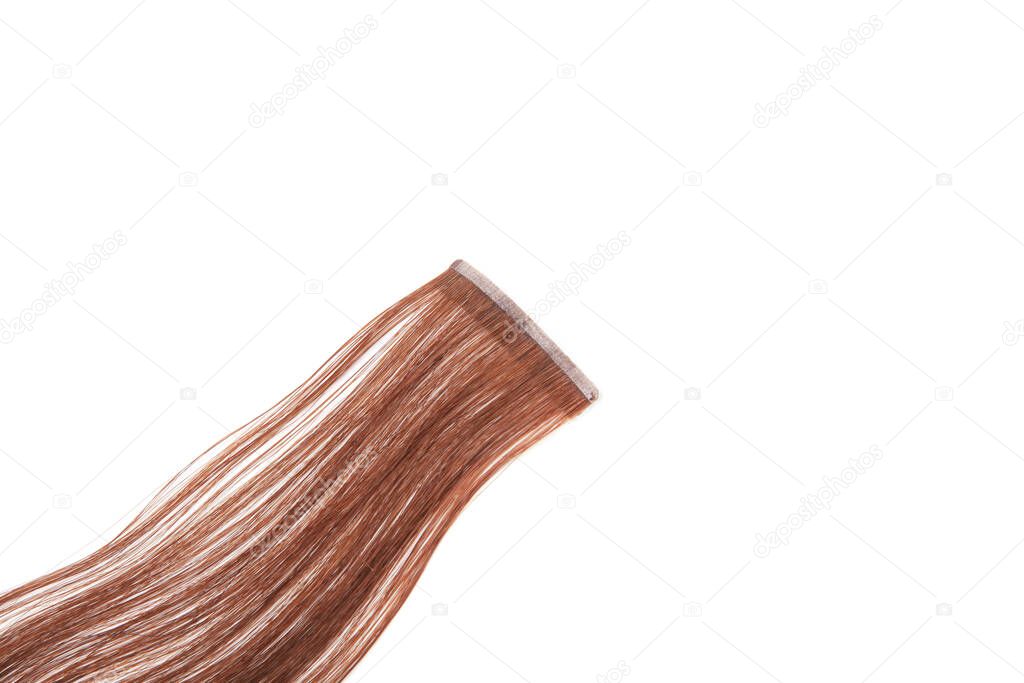 Fake brown hair on sticky tape on white isolated background