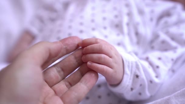 Vídeo em câmera lenta de um toque suave de uma mãe mão com mão seu bebê recém-nascido — Vídeo de Stock