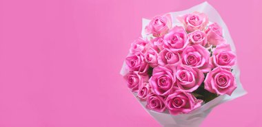 Pembe arka planda bir buket pembe gül, bir pankart.