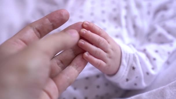 Slow motion video van een tedere aanraking van een moeders hand met de hand haar pasgeboren baby — Stockvideo