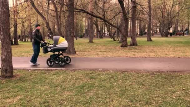 Slow-motion βίντεο του πατέρα με τα πόδια με νεογέννητο μωρό σε καροτσάκι το βράδυ — Αρχείο Βίντεο