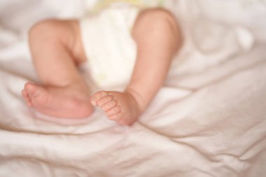 Bebek bacakları beyaz çarşafta, yeni doğmuş bebek 1 ay, ilgi ve sevgi
