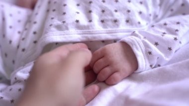 Bir annenin yeni doğmuş bebeğine dokunuşunun yavaş çekim videosu.