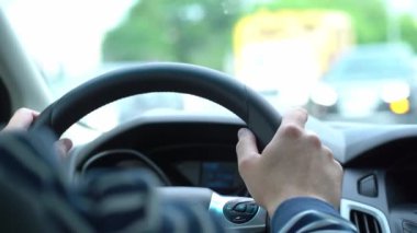 Şoför direksiyonda, direksiyonda bir adam ellerini direksiyonda tutar, arabanın içinden video.
