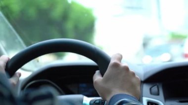 Şoför direksiyonda, direksiyonda bir adam ellerini direksiyonda tutar, arabanın içinden video.
