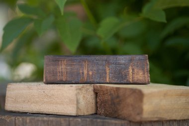 Yeşil arka planda ahşap bir podyum. Düz kare tribünler ya da doğal tasarım konsepti için podyum. Merkezi kompozisyon, ön görünüm