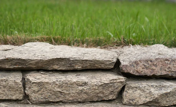 Exhibición del podio de piedra. Un pedestal de roca natural con un fondo verde natural. —  Fotos de Stock