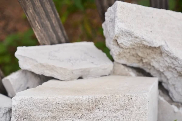 Stenpodium. Natursten piedestal av grå färg, på en sten bakgrund. — Stockfoto