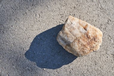 Ürün sunumu için podyum üstü görünümü. Bej renkli taş desenli ürün sergisi, güneş ışığında doğal güzelliğin bir kaidesi.