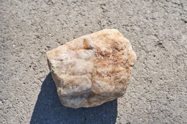 Ürün sunumu için podyum üstü görünümü. Bej renkli taş desenli ürün sergisi, güneş ışığında doğal güzelliğin bir kaidesi.