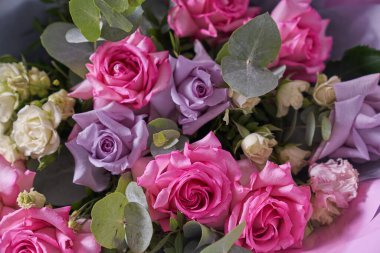 Yakından büyük bir buket çiçek. Büyük pembe güller. Hafif bir arka planda, üst görünümde. Yatay bileşim