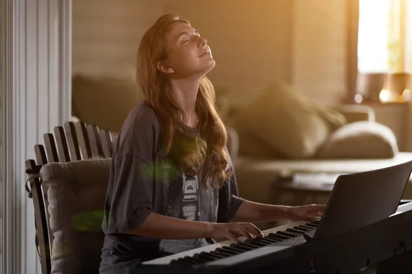 Uma jovem tocando piano. Close-up de uma jovem linda garota loira com cabelo avermelhado - marrom tocando piano-criativo, performance, conceito musical — Fotografia de Stock