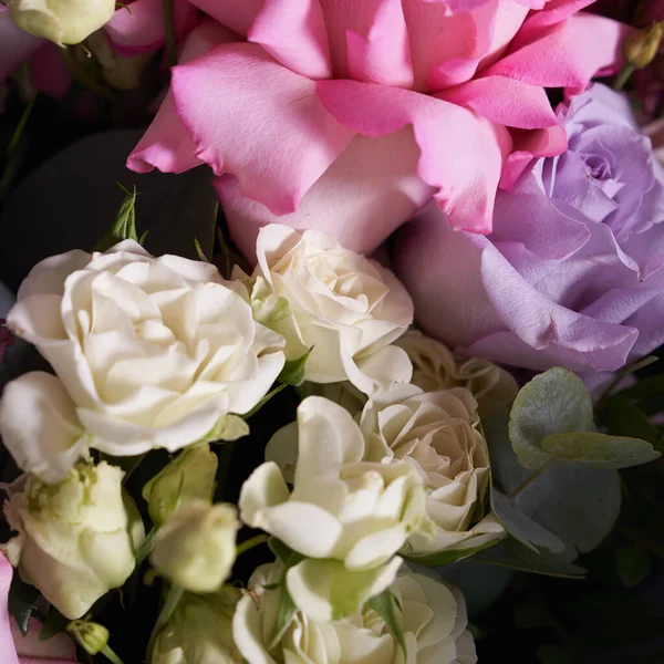 Gros plan d'un bouquet coloré de fleurs. Grandes roses roses et feuilles d'eucalyptus. Sur un fond clair, vue de dessus. — Photo