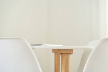 Sandalyeli şık beyaz bir masanın yakın çekimi. Modern ev dekorasyonu kavramı. Boşluğu kopyala.