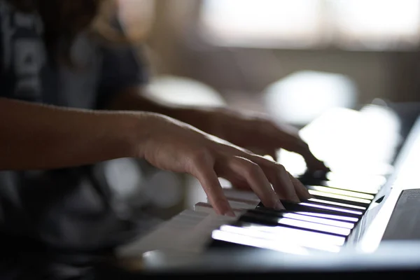 The musicians hands on the synthesizer. A cropped image of a person playing a synthesizer. Side view — Stock Photo, Image