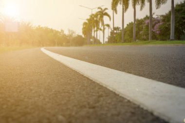 Bulanık arkaplan, ağaçlı sabah yolu ve güneş ışığı.