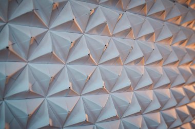 Üçgenlenmiş kağıt arka planı. İlginç ışık ile hacimsel şekiller.