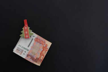 Siyah arkaplan parasıyla, mandallı, beş bininci Rus rublesiyle. Ekonomi konsepti, para dağılımı. Yeni yıl hediyesi..