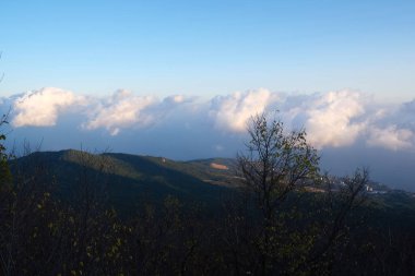 Görünür siluetleri olan dağ siluetleri sabah renkli sislerin arasında.
