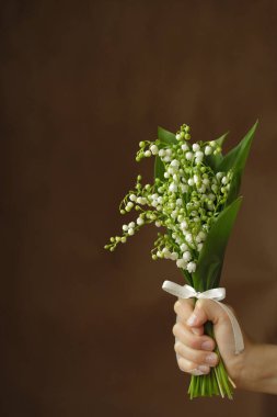 Karanlık bir arka planda, vadinin beyaz zambakları..