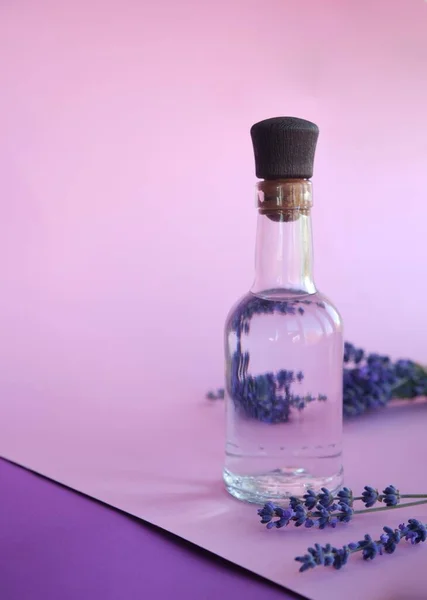 Natuurlijk aromatisch lavendelwater - hydrolaat en een boeket lavendelbloemen. — Stockfoto