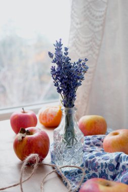 Bir demet lavanta, masanın üzerindeki pencerenin yanında elmalar..