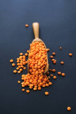 Koyu arkaplanda kırmızı mercimeğin üst görüntüsü. Vejetaryen. Boşluğu kopyala. 