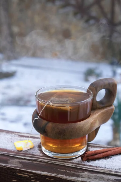 En kopp varmt svart te på snön. Te tid Royaltyfria Stockbilder