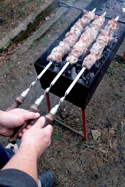 En man förbereder en utegrill utanför sitt hus. — Stockfoto