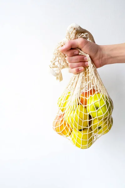 Manzanas en una bolsa de hilo en la mano. Frutas orgánicas frescas naturales. dieta alimentaria. — Foto de Stock