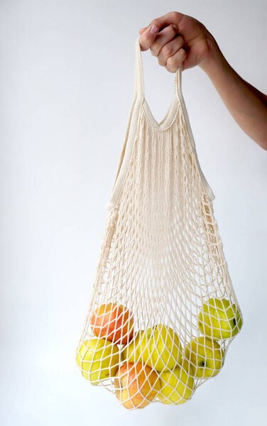 Apples in a string bag in hand. Natural fresh organic fruits. food diet. 