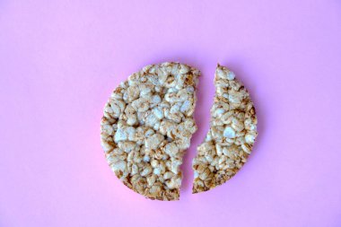 Fotokopi alanı olan pembe arka planda kırılmış pirinç keki. Yukarıdan görüntüle.